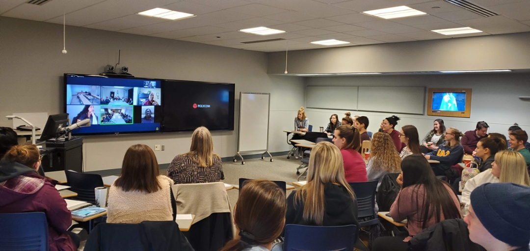 An in-person class connecting with another class on screen