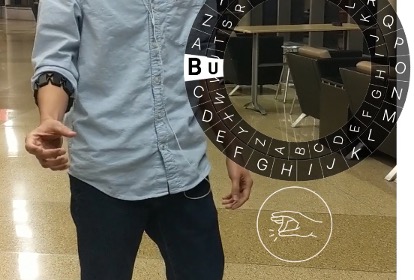 Image showing a person wearing an input device on their arm that converts gesture into typed text in a nonvisual display